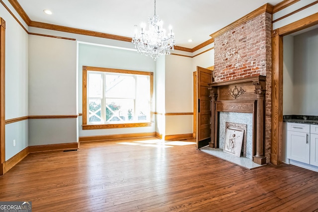 unfurnished living room featuring wood finished floors, baseboards, and a large fireplace