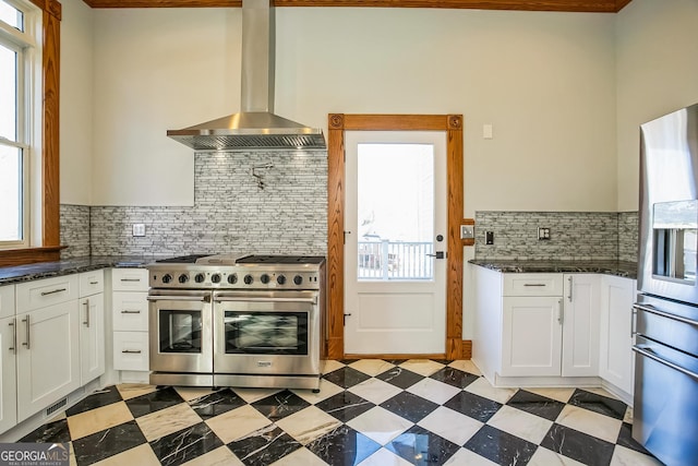 kitchen with tasteful backsplash, white cabinetry, ventilation hood, stainless steel appliances, and light floors