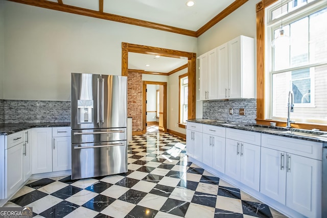 kitchen with stainless steel fridge, ornamental molding, a healthy amount of sunlight, and a sink