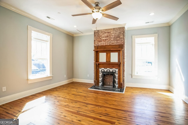 unfurnished living room with visible vents, a fireplace, baseboards, and hardwood / wood-style flooring