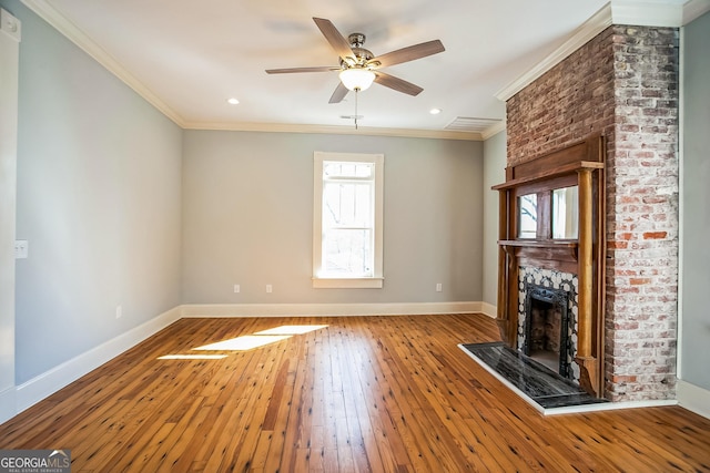 unfurnished living room featuring a fireplace with raised hearth, baseboards, ornamental molding, a ceiling fan, and wood-type flooring