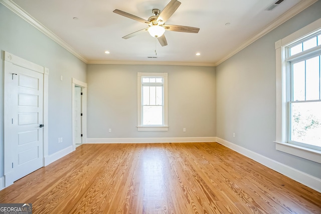 empty room featuring a wealth of natural light, light wood-type flooring, and baseboards