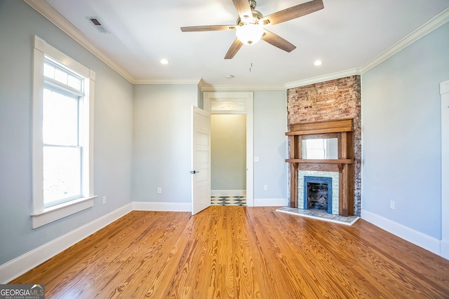 unfurnished living room featuring wood finished floors, baseboards, visible vents, a fireplace, and ornamental molding