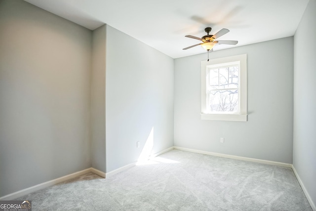 unfurnished room with carpet flooring, a ceiling fan, and baseboards