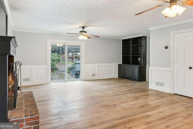 unfurnished living room with visible vents, a textured ceiling, ornamental molding, and light wood-style flooring