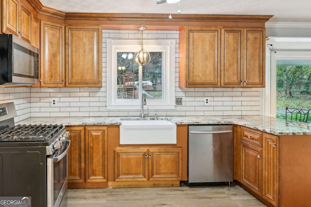 kitchen with plenty of natural light, brown cabinets, appliances with stainless steel finishes, and a sink