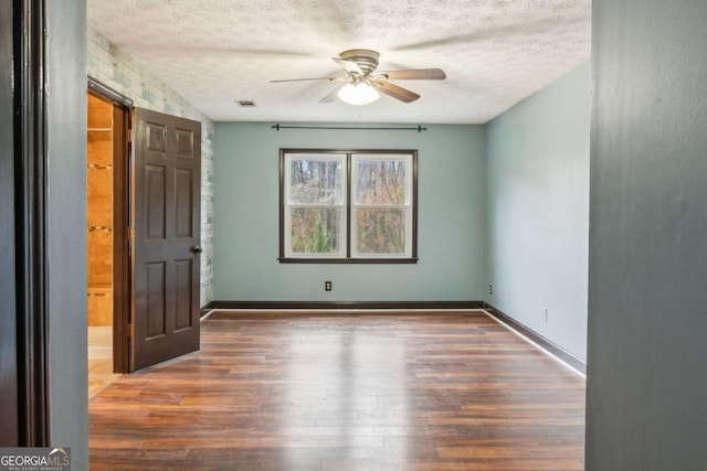 unfurnished bedroom with visible vents, baseboards, a textured ceiling, and wood finished floors