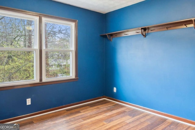 unfurnished room featuring wood finished floors and baseboards