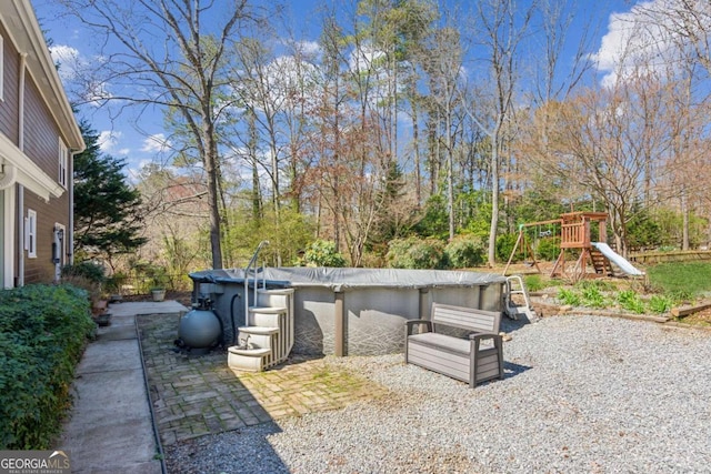 view of patio / terrace featuring a covered pool and a playground