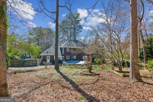 back of property with a trampoline and fence