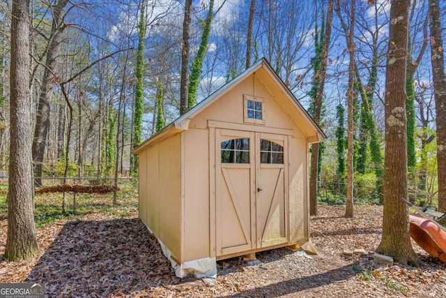 view of shed featuring fence