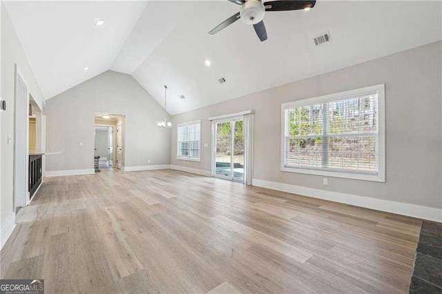 unfurnished living room featuring visible vents, baseboards, ceiling fan with notable chandelier, light wood-style floors, and high vaulted ceiling