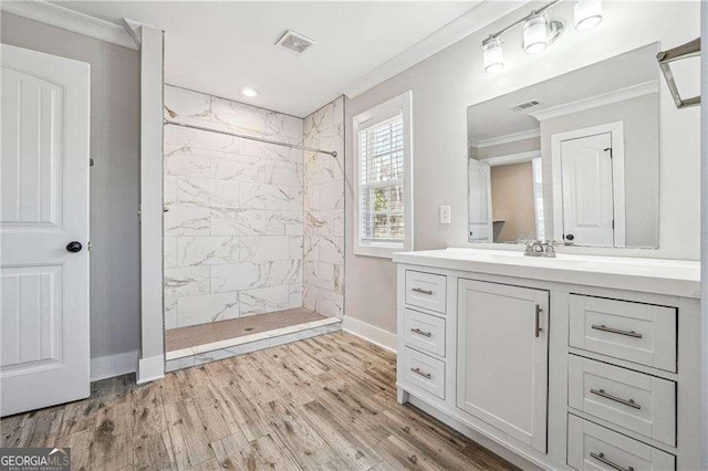 bathroom featuring visible vents, tiled shower, and ornamental molding