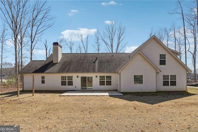 rear view of property with a chimney and a patio area