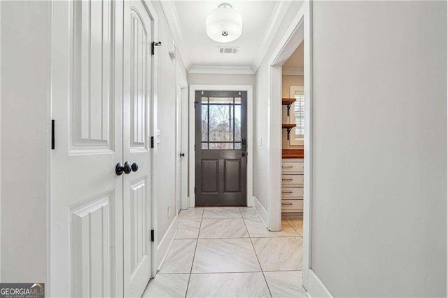 doorway to outside featuring visible vents, baseboards, and ornamental molding