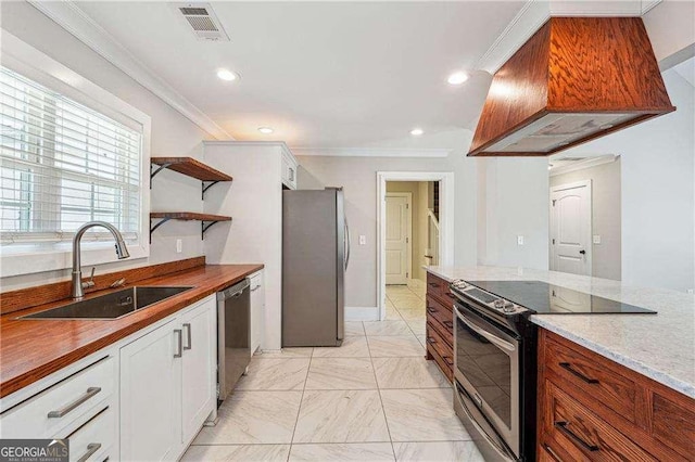 kitchen featuring visible vents, custom exhaust hood, a sink, appliances with stainless steel finishes, and crown molding