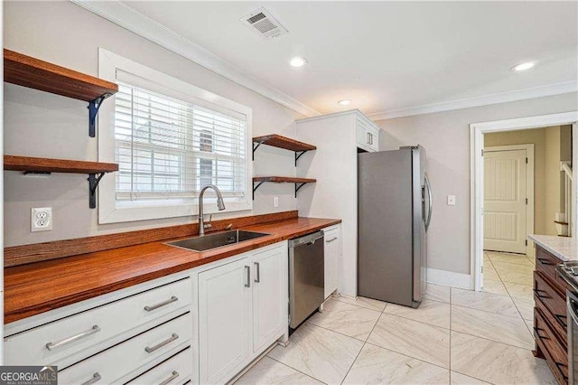 kitchen with visible vents, open shelves, ornamental molding, a sink, and appliances with stainless steel finishes