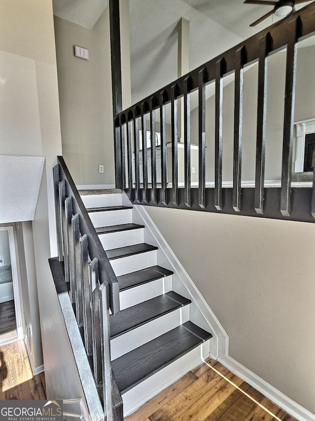 stairway with baseboards and wood finished floors