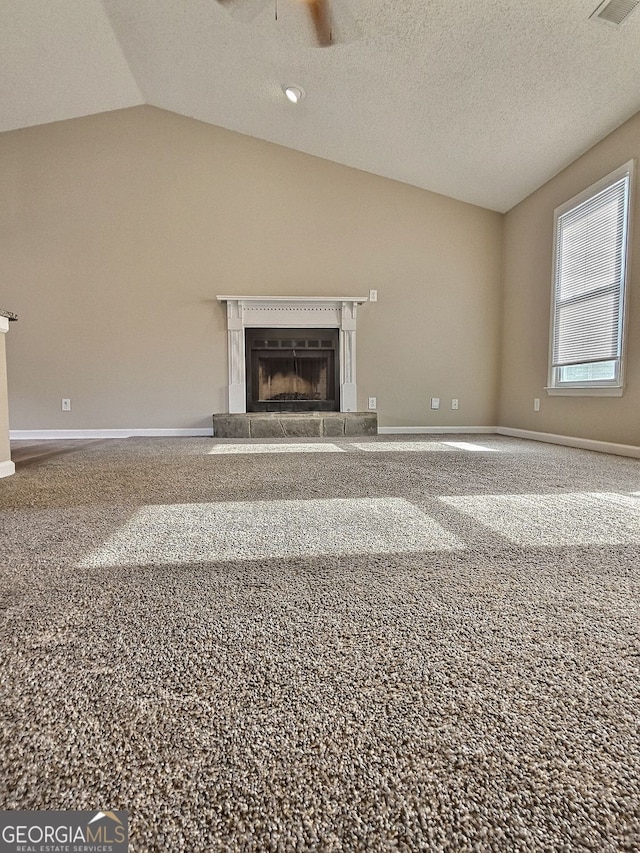 unfurnished living room with a fireplace with raised hearth, baseboards, a ceiling fan, and vaulted ceiling