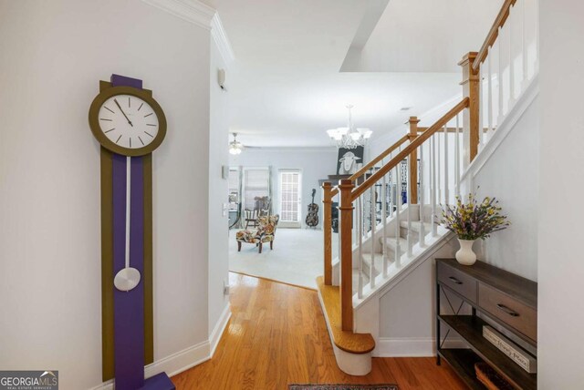 hall featuring stairway, ornamental molding, and wood finished floors