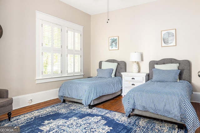 bedroom with baseboards and wood finished floors