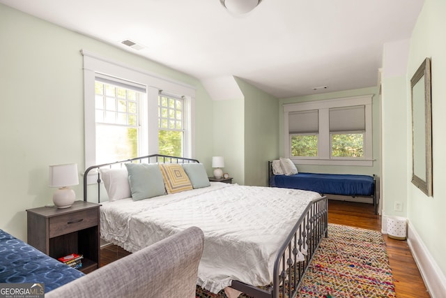 bedroom featuring visible vents, baseboards, and wood finished floors