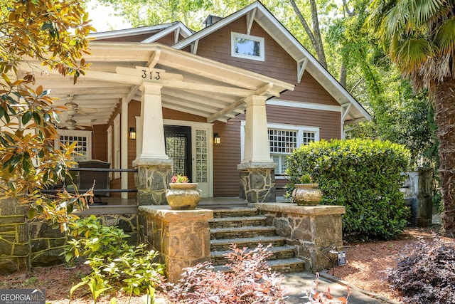 view of exterior entry featuring covered porch and a ceiling fan