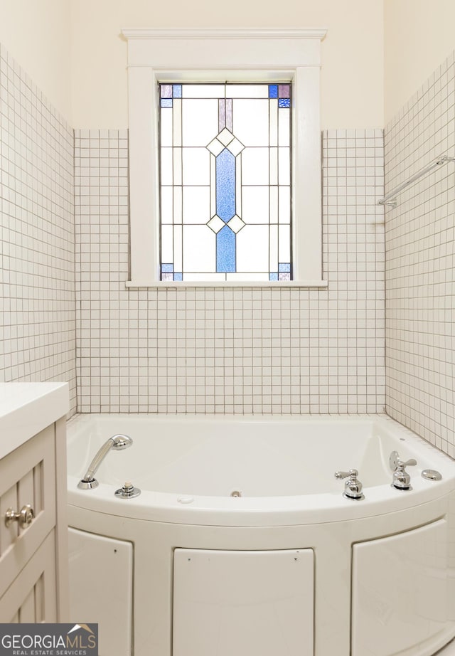 full bathroom with a jetted tub and vanity