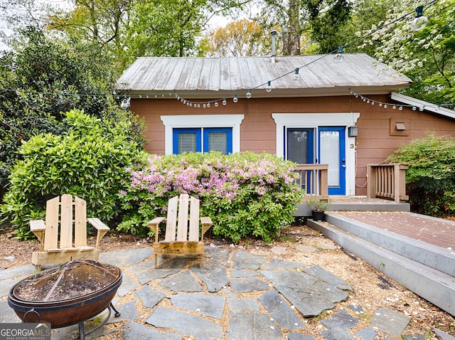 view of front of property with metal roof, a patio area, and an outdoor fire pit