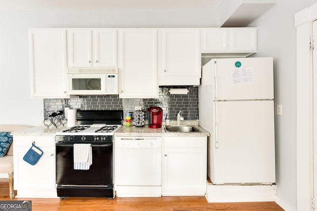 kitchen featuring light wood finished floors, decorative backsplash, white appliances, and white cabinetry