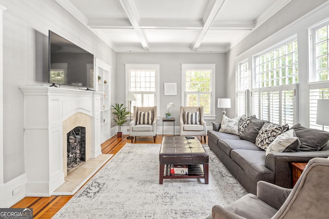 living area with light wood finished floors, baseboards, beam ceiling, a fireplace, and coffered ceiling