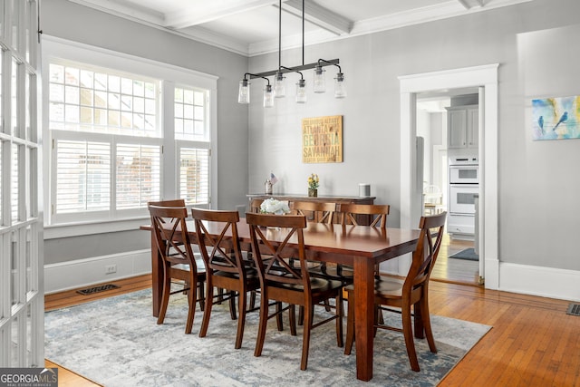 dining space featuring visible vents, plenty of natural light, ornamental molding, and hardwood / wood-style floors