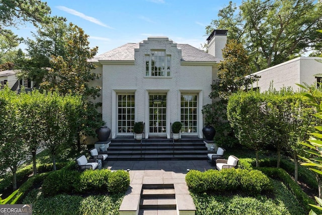 rear view of property with entry steps and a chimney