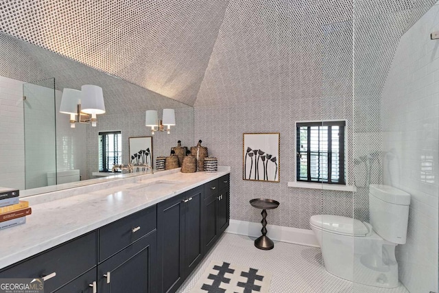 full bath with tile patterned floors, toilet, vanity, and vaulted ceiling