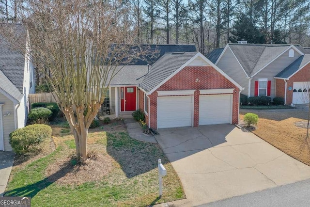 view of front of property with a garage, brick siding, concrete driveway, and fence