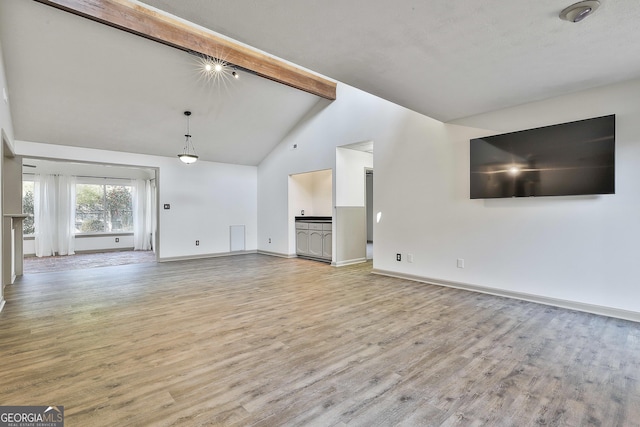 unfurnished living room featuring light wood finished floors, beamed ceiling, high vaulted ceiling, and baseboards