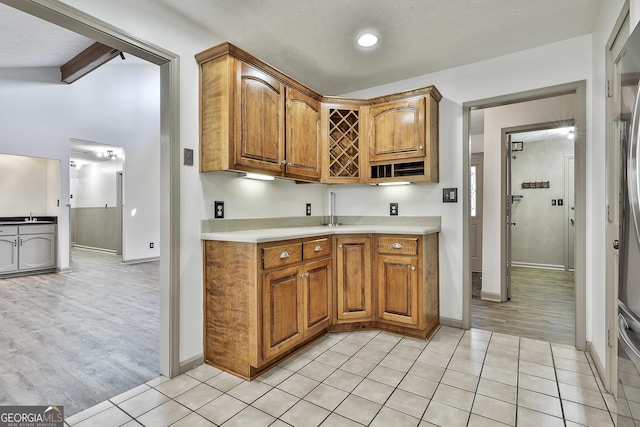 kitchen featuring light tile patterned floors, brown cabinets, and light countertops