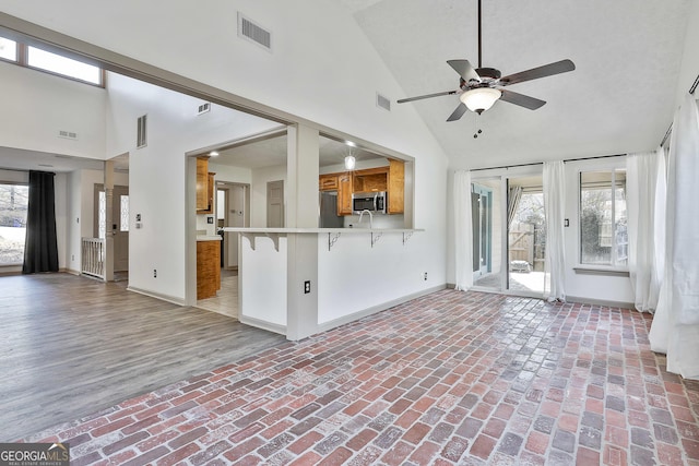 interior space with visible vents, a healthy amount of sunlight, baseboards, and brick floor