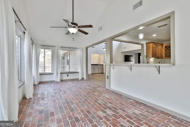 unfurnished sunroom featuring a ceiling fan, visible vents, and a sink