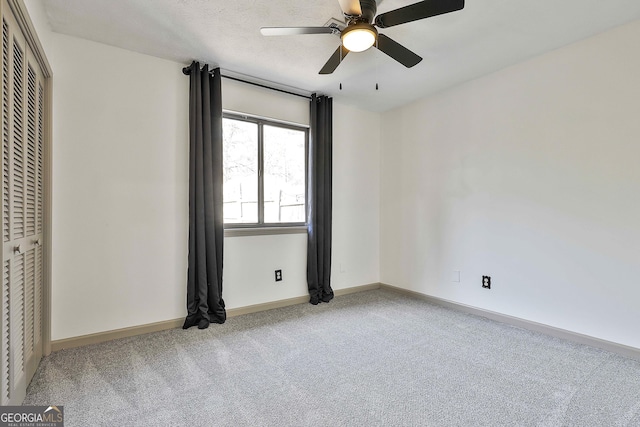 unfurnished bedroom featuring baseboards, carpet floors, ceiling fan, a closet, and a textured ceiling