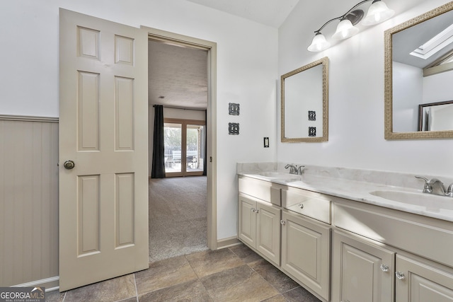 bathroom with double vanity, stone finish floor, and a sink