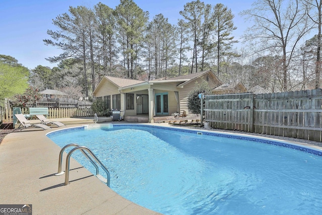 view of swimming pool featuring a patio area, a fenced in pool, and fence