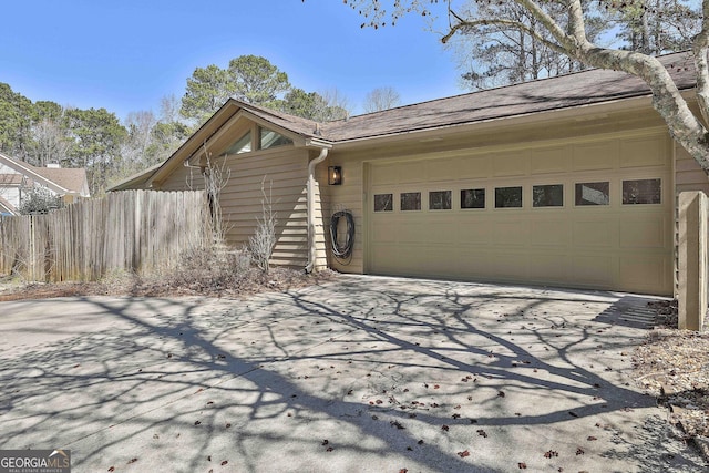 exterior space featuring a garage and fence