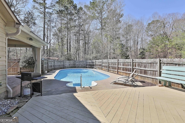 view of pool with a fenced in pool, a grill, a wooden deck, and a fenced backyard