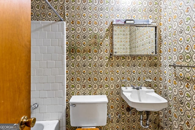 bathroom featuring shower / washtub combination, toilet, and a sink