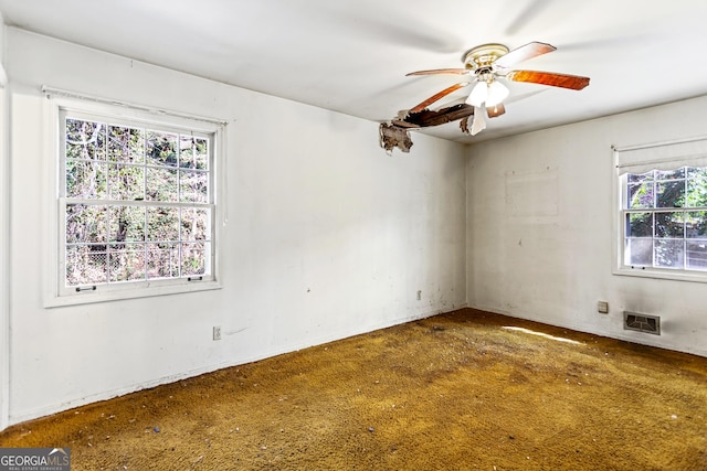 unfurnished room with a ceiling fan, a healthy amount of sunlight, and visible vents