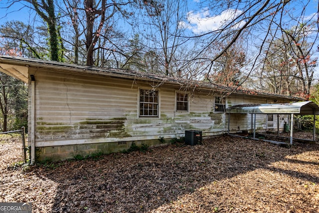 exterior space featuring a detached carport, cooling unit, and fence