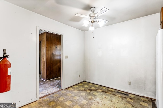 spare room featuring tile patterned floors, visible vents, baseboards, and a ceiling fan