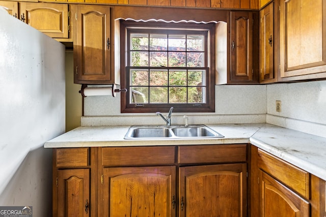 kitchen featuring a sink, brown cabinets, a healthy amount of sunlight, and light countertops