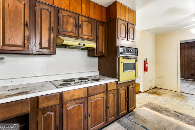 kitchen featuring white appliances, light countertops, and under cabinet range hood